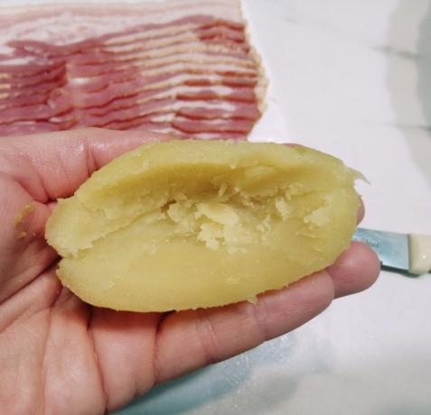 Skala potatisen, skär den i två halvor med en kniv försiktigt skära ut mitten